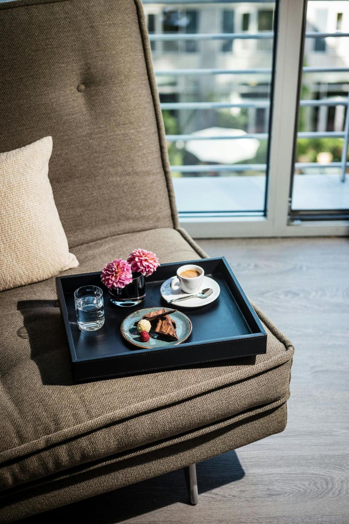 Le Meridien Мюнхен Экстерьер фото A tray with a cup of coffee and a dessert